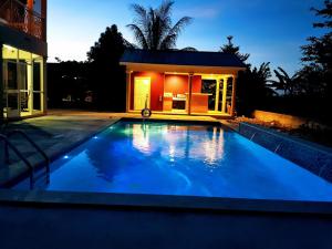 a swimming pool in front of a house at night at Casa de Bells 2 in George Town