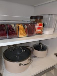 a pot and pans sitting on a shelf in a refrigerator at Modern Private Suite - Quiet & Central Winnipeg in Winnipeg +63 photos