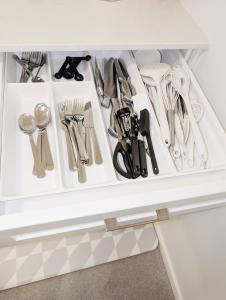 a drawer filled with utensils in a cabinet at Modern Private Suite - Quiet & Central Winnipeg in Winnipeg