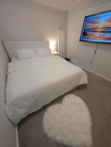 a bedroom with a white bed and a white rug at Modern Private Suite - Quiet & Central Winnipeg in Winnipeg