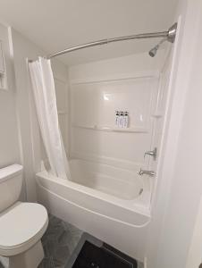 a bathroom with a tub and a toilet and a shower at Modern Private Suite - Quiet & Central Winnipeg in Winnipeg