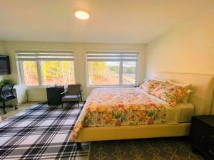 a bedroom with a bed and a desk and two windows at Morning Dew105 in Hammonds Plains
