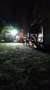 a barn at night with a light in the background at Puerto Ballena in Las Toninas