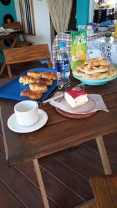 a table topped with plates of pastries and a slice of cake at Puerto Ballena in Las Toninas