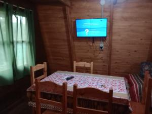 a dining room with a table and a television at Puerto Ballena in Las Toninas