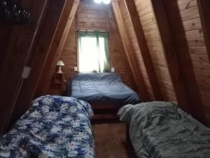 two beds in a small room with a window at Puerto Ballena in Las Toninas