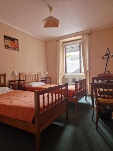 a bedroom with three beds and a window at Hôtel de la Gare - Morlaix in Morlaix +14 photos