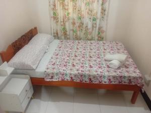 a small bedroom with a bed and a curtain at Moalboal Homestay VILLA in Tomonoy