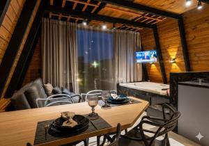 a living room with a table and chairs and a television at Chalé Exclusivo Com Hidro em Meio a Natureza in Blumenau