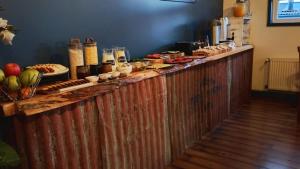a long wooden counter with food on top of it at Pristine Patagonia Hotel in Puerto Natales