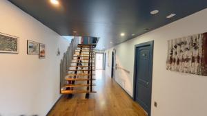 a hallway with a wooden staircase in a house at Pristine Patagonia Hotel in Puerto Natales