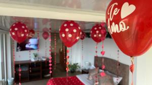 a room with red balloons hanging from a bed at Hotel Rocamonti in Aquitania