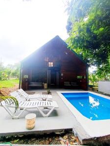 a house with a swimming pool and chairs and a building at Cabaña Kono Rainbow Finca paraíso in Jiménez +27 photos