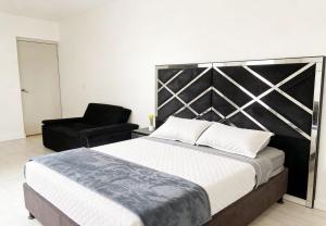 a bedroom with a large bed and a chair at Room cerca al aeropuerto #2 in Bogotá