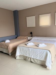 a room with two beds with towels on them at Casa Olivia in Luján