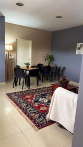 a living room with a table and chairs and a rug at Casa Olivia in Luján