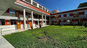 an empty courtyard of a building with a grass yard at Hostal Bon in Nazca