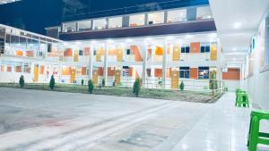 a large white building with yellow and orange windows at Hostal Bon in Nazca