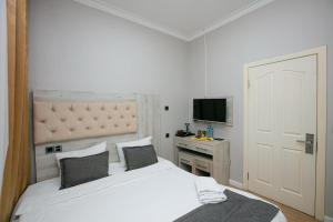 a bedroom with a white bed and a television at Empire Hotel Baku F1 view in Baku +50 photos