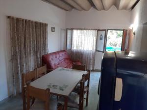 a living room with a table and a red chair at El Viejo Nogal in Gómez