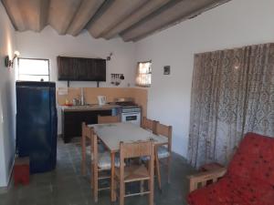 a kitchen with a table and chairs and a refrigerator at El Viejo Nogal in Gómez
