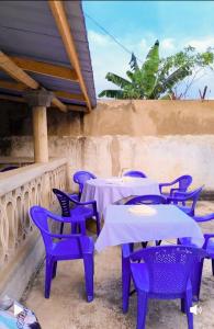 a group of purple tables and chairs on a patio at Villa Frisi in Palimé