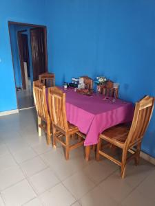 a dining room table with a purple table cloth at Villa Frisi in Palimé