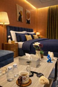 a bedroom with a blue bed and a table with a coffeeucer at هابي رومز - شقق فندقية في الخبر in Al Khobar