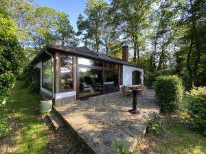 a small house with glass doors and a patio at Boogie House in Rendeux