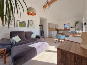 ein Wohnzimmer mit einem lila Sofa und eine Küche in der Unterkunft Fonse in Pettendorf