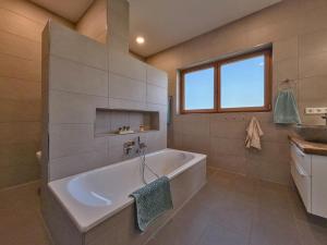 ein großes Badezimmer mit Badewanne und Waschbecken in der Unterkunft Fonse in Pettendorf + 35 Fotos