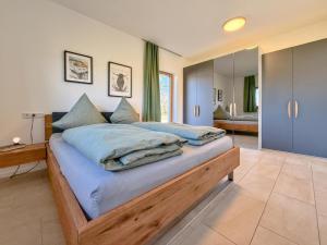 ein Schlafzimmer mit einem großen Bett mit blauen Laken in der Unterkunft Fonse in Pettendorf