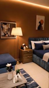 a living room with a bed and a table at هابي رومز - شقق فندقية في الخبر in Al Khobar +47 photos