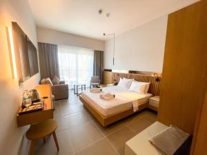 a hotel room with a bed and a living room at Blue Inn Hotel in Gökçeada