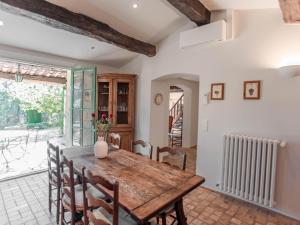 a dining room with a wooden table and chairs at Le Mas dormant in Fayence