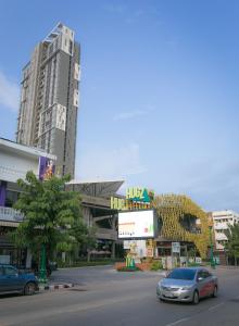 una calle de la ciudad con coches estacionados frente a los edificios en Grand Leo Hotel, en Khon Kaen