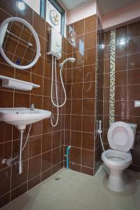 a bathroom with a toilet and a sink and a shower at Grand Leo Hotel in Khon Kaen
