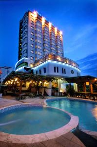 um hotel com piscina em frente a um edifício em The Light Hotel em Nha Trang