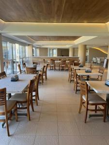 a dining room with tables and chairs in a building at Pé na areia - verdadeiro paraíso em Muro Alto in Porto De Galinhas