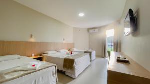 a hotel room with two beds and a television at Caldas Park e Hotel - Caldas Novas in Caldas Novas +151 photos