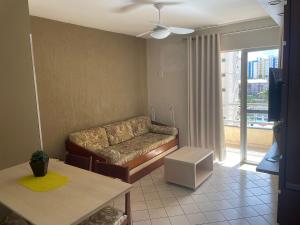 a living room with a couch and a table at Eldorado Flat Service Host Hub | Localização Top em frente ao Clube Privé in Caldas Novas