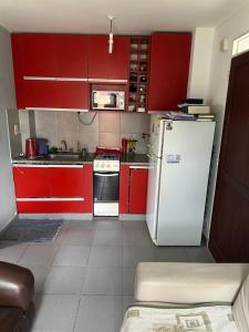 a kitchen with red cabinets and a white refrigerator at Mica in Salta