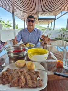 a man sitting at a table with a plate of food at Hotel Betania in Jaén