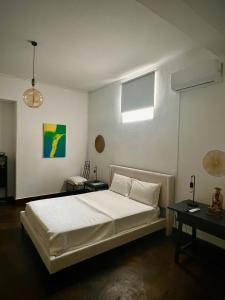 a bedroom with a white bed and a window at 1955 Guest House in Cebolais de Cima