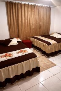 two beds sitting in a room with curtains at Chácara Sossego in Viçosa do Ceará