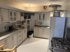 a kitchen with white cabinets and a white refrigerator at شاليه ماديرا in Hail +8 photos