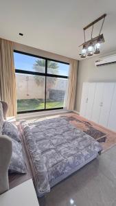 a large bed in a room with a large window at شاليه ماديرا in Hail