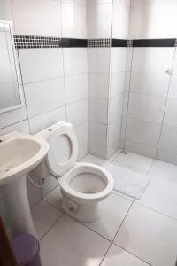 a white bathroom with a toilet and a sink at Chácara Sossego in Viçosa do Ceará +12 photos