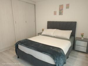 a bedroom with a bed with a black and white blanket at Room cerca al aeropuerto #4 in Bogotá +10 photos