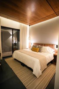 a bedroom with a large bed with a wooden ceiling at Hotel Agua de Plata in San Luis Potosí